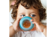 Image Baby drinking from a bottle.